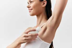Woman with hyperhidrosis applying prescription antiperspirant